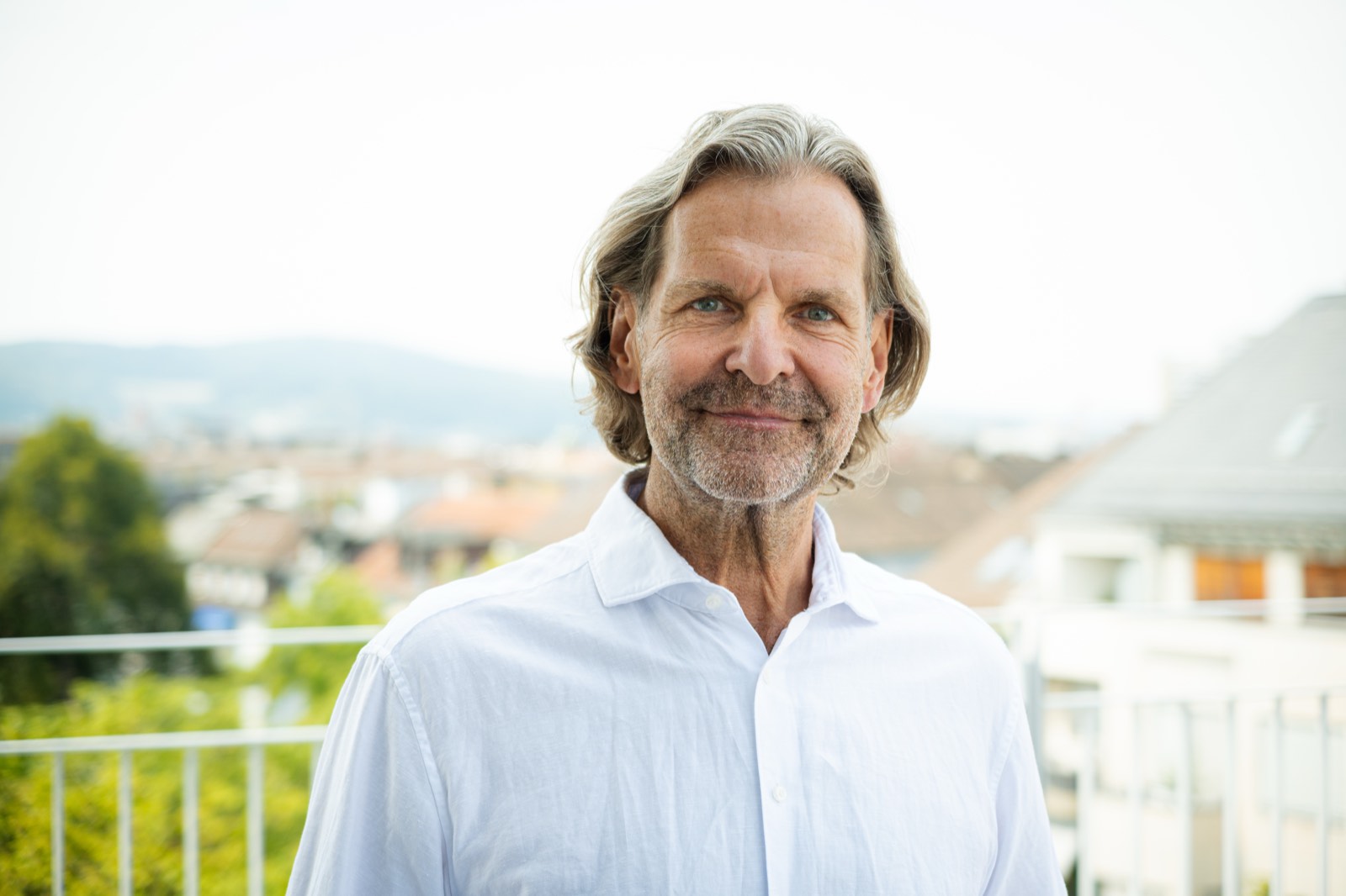 Dr. med. Stefan Wehrle auf einer Dachterrasse über den Dächern von Zürich